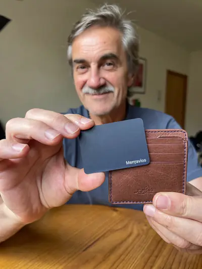 Un homme montre une carte Merravios dans son portefeuille